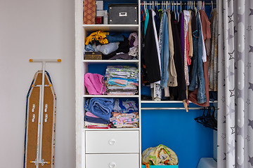 Image showing Fragment of the interior of the room, a closet with linen, next to an ironing board