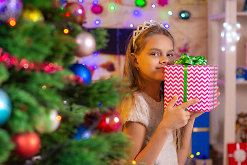 Image showing Happy girl with a gift at the Christmas tree
