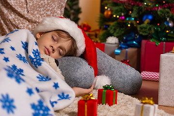 Image showing Girl lies on mom\'s lap at Christmas tree