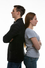 Image showing A man and a woman stand with their backs to each other, with their arms folded on their chests