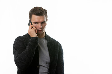 Image showing Portrait of a sad young man talking on the phone