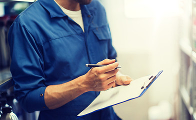 Image showing auto mechanic with clipboard at car workshop