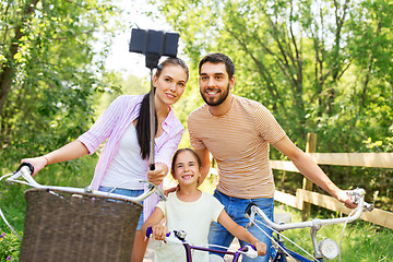Image showing happy family with bicycles taking selfie in summer