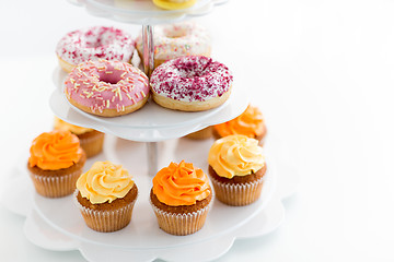 Image showing glazed donuts, cupcakes with frosting on stand