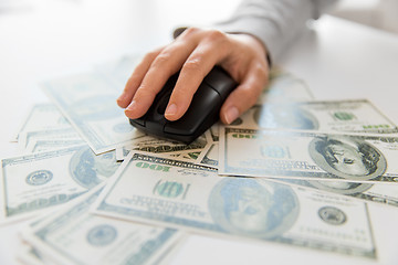 Image showing close up of hand with computer mouse on money