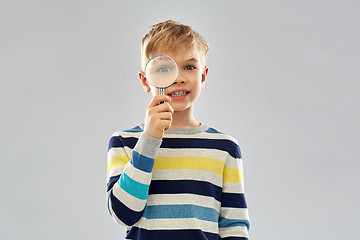 Image showing curious boy looking through magnifying glass