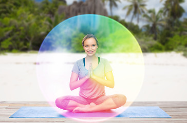 Image showing woman doing yoga in lotus pose with rainbow aura