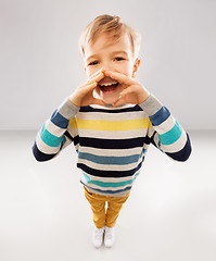 Image showing little boy in striped pullover calling someone