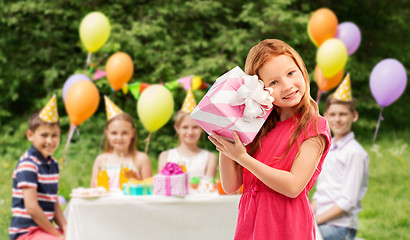 Image showing lovely red haired girl with birthday gift at party