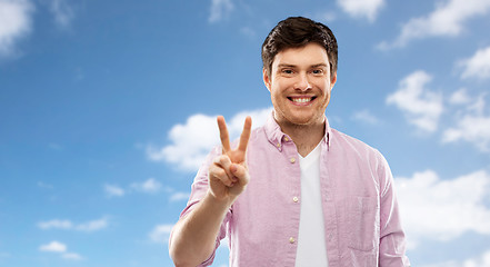 Image showing man showing two fingers or peace sign over sky