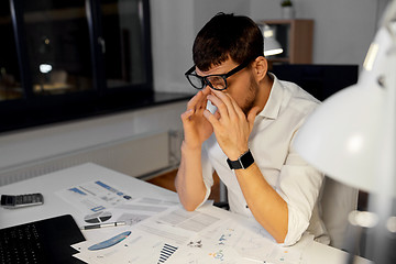 Image showing tired businessman working at night office