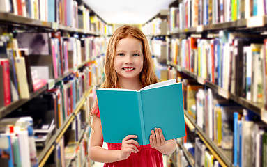 Image showing smiling red haired girl reading book at library