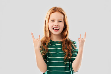 Image showing smiling red haired girl showing rock gesture