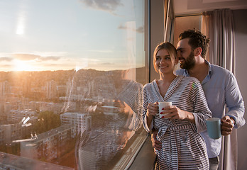 Image showing young couple enjoying evening coffee by the window