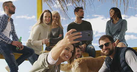 Image showing Group of friends having fun on autumn day at beach