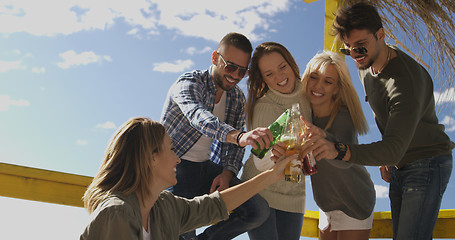 Image showing Group of friends having fun on autumn day at beach