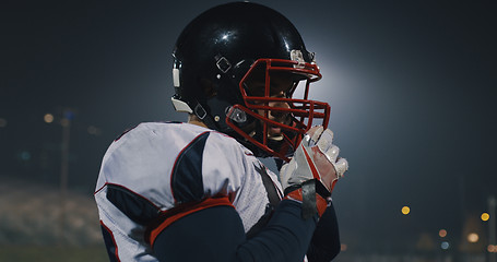 Image showing American Football Player Putting On Helmet on large stadium with