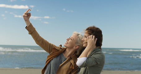 Image showing Girls having time and taking selfie on a beach