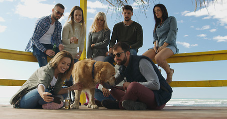 Image showing Group of friends having fun on autumn day at beach