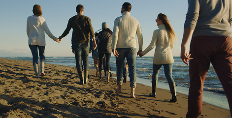 Image showing Group of friends having fun on beach during autumn day