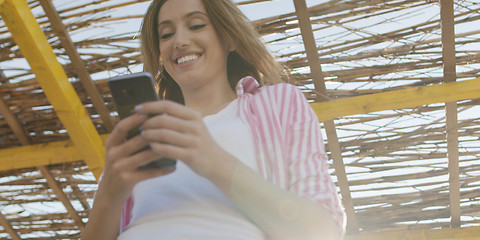 Image showing Smartphone Woman Texting On Cell Phone At Beach