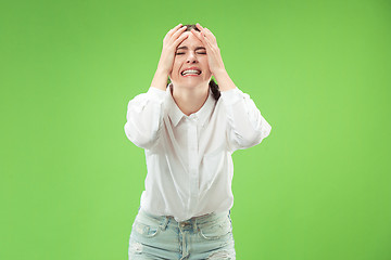 Image showing Beautiful woman looking suprised and bewildered isolated on green