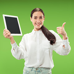 Image showing Portrait of a confident casual girl showing blank screen of laptop isolated over green background