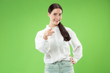 Image showing The happy business woman point you and want you, half length closeup portrait on green background.