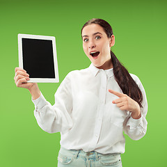 Image showing Portrait of a confident casual girl showing blank screen of laptop isolated over green background