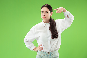 Image showing The overbearing business woman point you and want you, half length closeup portrait on green background.