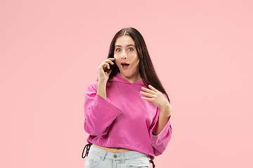 Image showing Young beautiful woman using mobile phone studio on pink color background