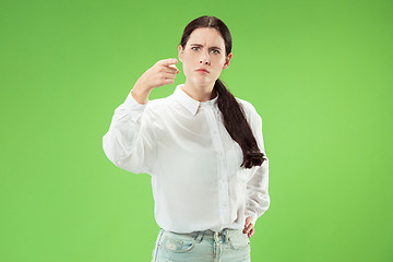 Image showing The overbearing business woman point you and want you, half length closeup portrait on green background.