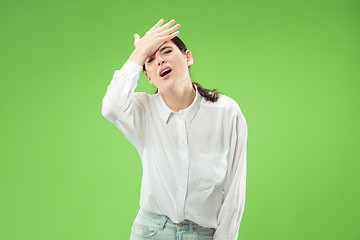 Image showing Beautiful woman looking suprised and bewildered isolated on green