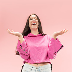 Image showing The happy business woman standing and smiling against pink background.