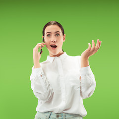 Image showing Young beautiful woman using mobile phone studio on green color background