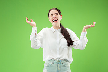 Image showing The happy business woman standing and smiling against green background.