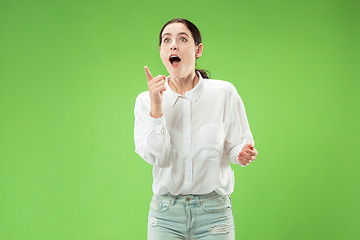 Image showing Beautiful woman looking suprised isolated on green