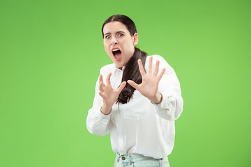 Image showing Portrait of the scared woman on green