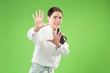 Image showing Portrait of the scared woman on green