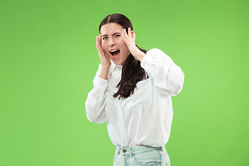 Image showing Portrait of the scared woman on green