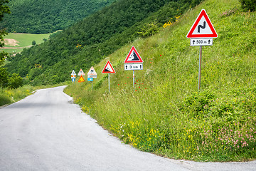 Image showing some street signs on a steep road