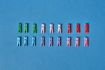 Image showing Two lines of colorful clothespins with shadows.