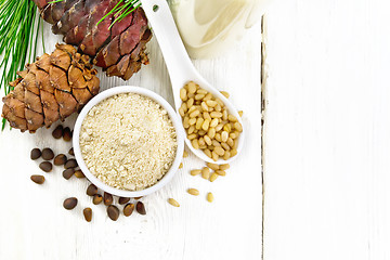 Image showing Flour cedar in bowl and nuts in spoon on light board top