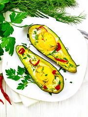 Image showing Scrambled eggs with peppers in avocado on light board top