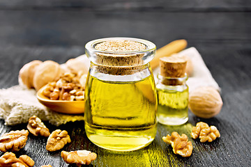 Image showing Oil walnut in jar with spoon on board