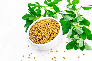 Image showing Fenugreek with green leaves in bowl on light board