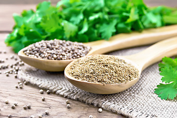 Image showing Coriander ground and seeds in two spoons on old board