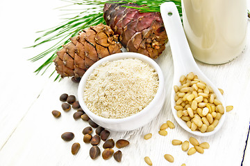 Image showing Flour cedar in bowl and nuts in spoon on light board