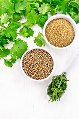 Image showing Coriander ground and seeds in bowls on board top