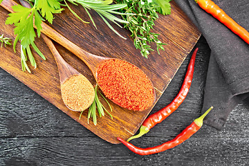 Image showing Peppers red and paprika powder in spoon on board top